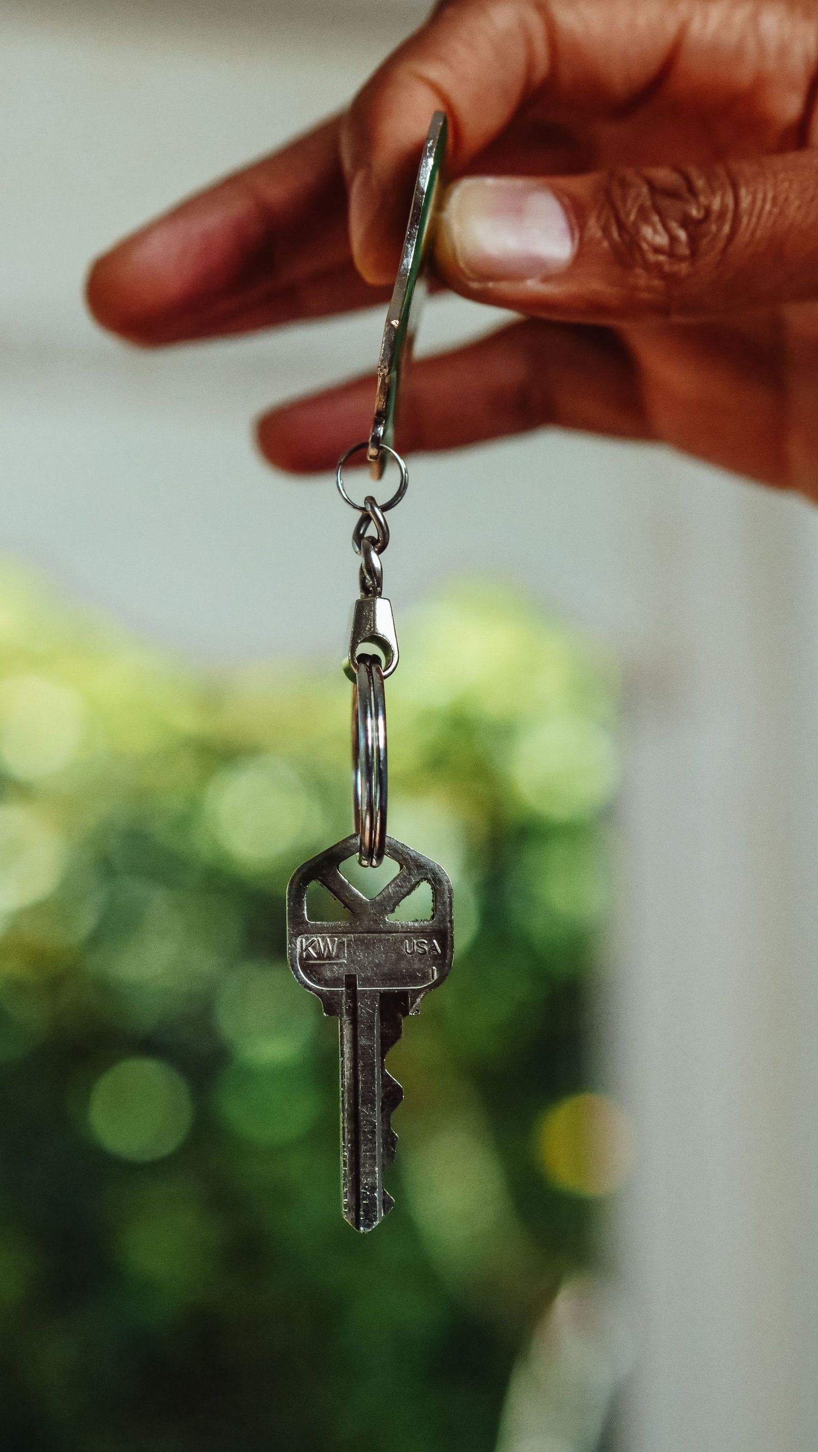 A new homeowner holding house keys in front of their front door