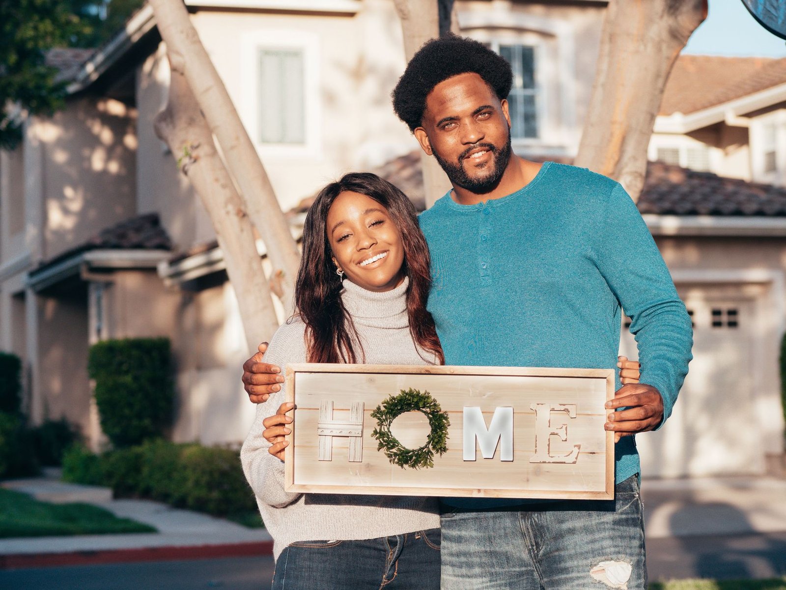 A couple celebrating in front of their newly purchased home